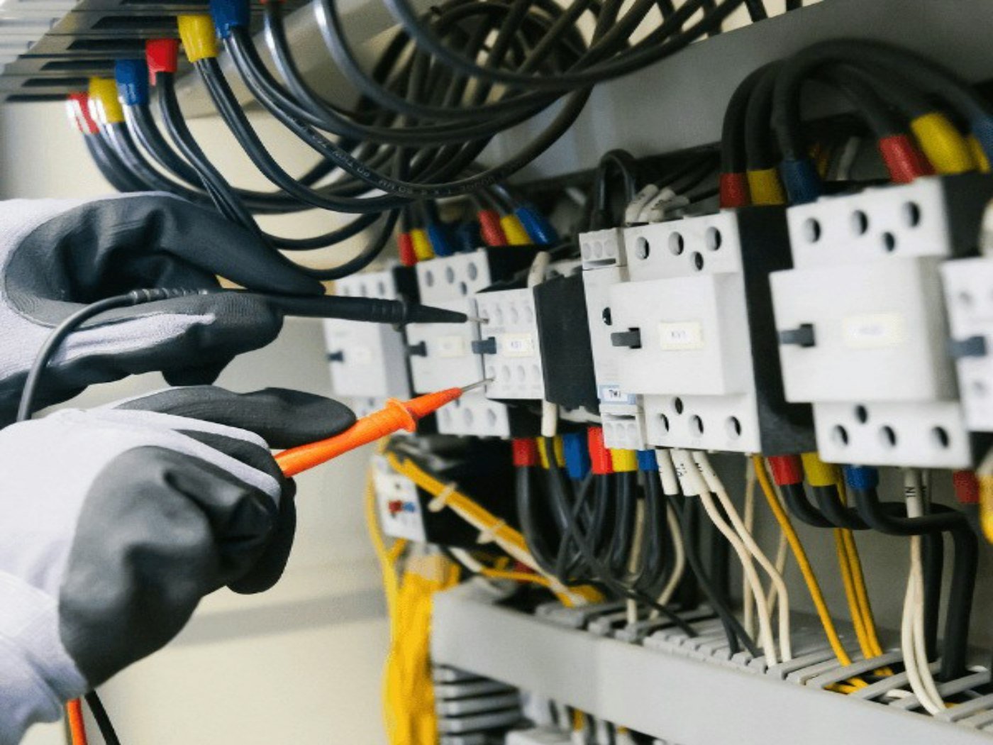 Électricien contrôlant un tableau au multimètre